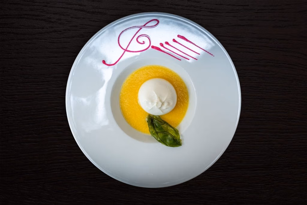 Cuore di burrata su vellutata di datterini e basilico croccante